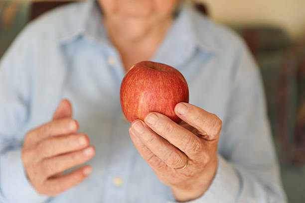istock Senior Female With Apple Representing Wellness And Nutrition 2248404945
