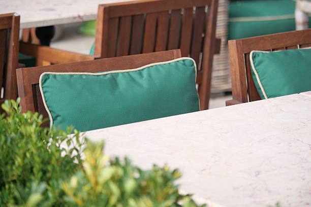 istock Outdoor dining setup with green cushions and table 2248405056