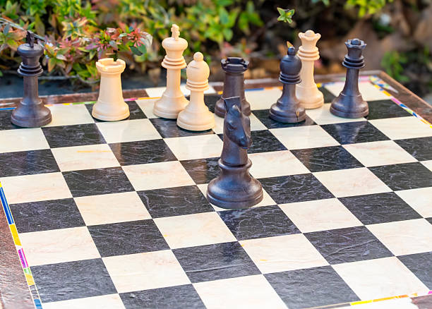 istock Chess board with black and white chess pieces arranged for a game outdoors 2248406900