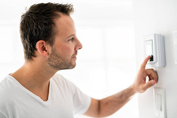 istock A man set the thermostat at house 2248407086