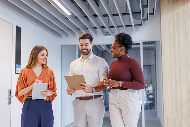 istock Diverse business people discussing casually while walking in office corridor 2248407946