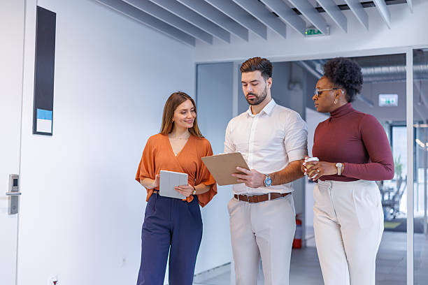 istock Business colleagues discussing project ideas while walking in office 2248407988