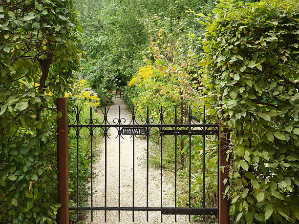 istock Rustic wrought iron garden gate with PRIVATE sign and lush garden background 2248408181