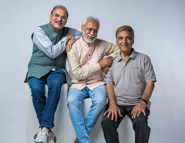 istock Senior friends sitting on blocks against white background 2248409566