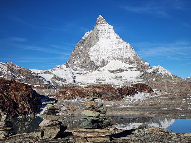 This image shows a clear view of the Matterhorn, one of the most iconic peaks in the Swiss Alps. The dramatic mountain rises above the surrounding alpine landscape, creating a classic Swiss scenery popular with hikers, climbers, and travelers from around the world.