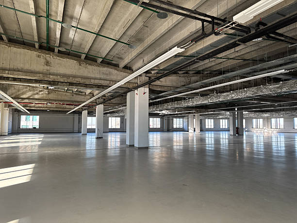 istock Renovation industrial space or factory floor. Spacious, empty manufacturing bay. Vacant production facility or warehouse space. Warm shell 2248412207