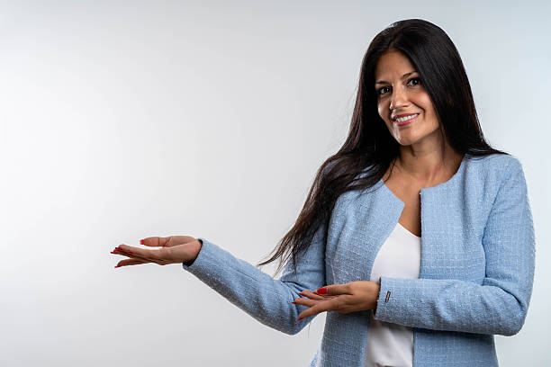 istock Cheerful woman pointing at product placement on a grey background. 2248412797