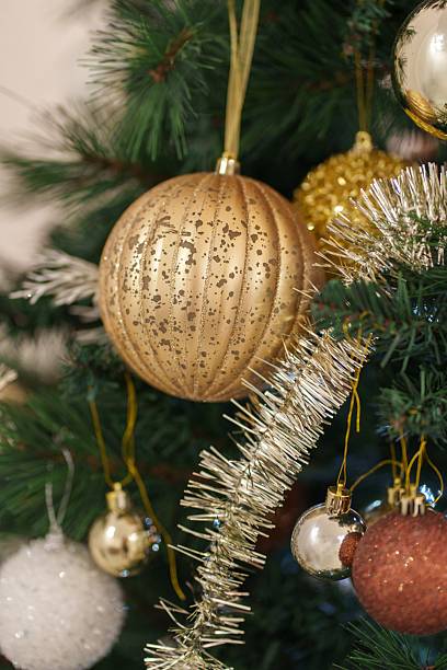 istock Festive golden ornament with sparkles hangs on a beautifully decorated Christmas tree 2248414610