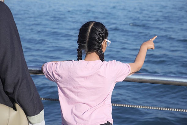 istock Child points at the water from a boat on a sunny day 2248417311