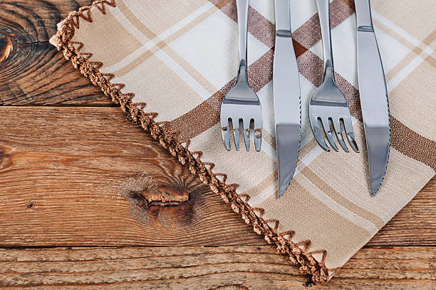 Wooden table set with cutlery and napkins horizontal shot