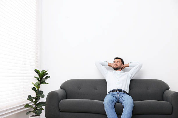 istock Happy man resting on sofa at home. Space for text 2248421823