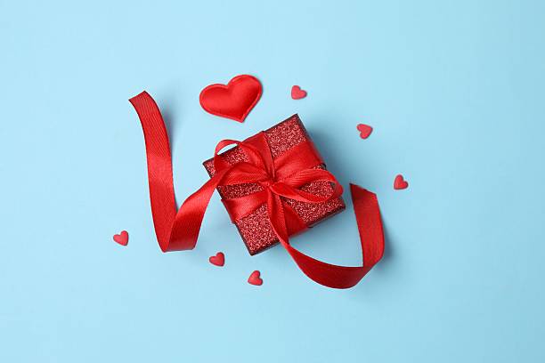 istock Gift box with red hearts on color  background 2248422606