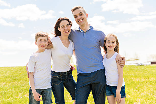 A Family of four outdoors in a field having fun