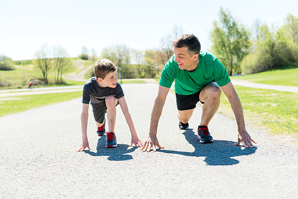 Father and son running together in the park.