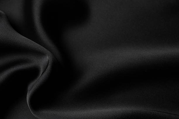 istock Black silk satin. Shiny smooth fabric. Soft folds. Luxury background with space for design. Flat table, top view 2248426374