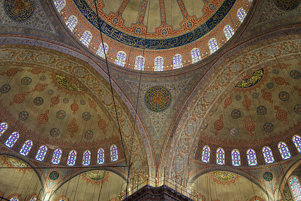 The image features intricate dome architecture with arches, ornate decorations, and stained glass windows, showcasing detailed craftsmanship in religious architecture. Istanbul, Turkey.