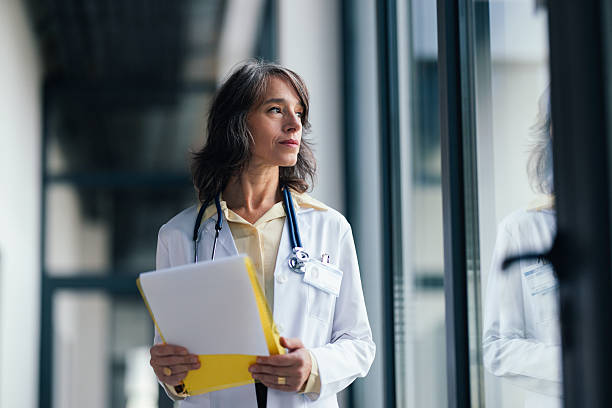 istock Experienced Doctor in White Coat With Stethoscope Holding Folder in Modern Hospital Corridor 2248434723