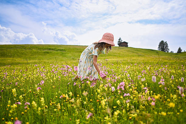 Happy girl searching for colorful blossoms in a vast blooming field