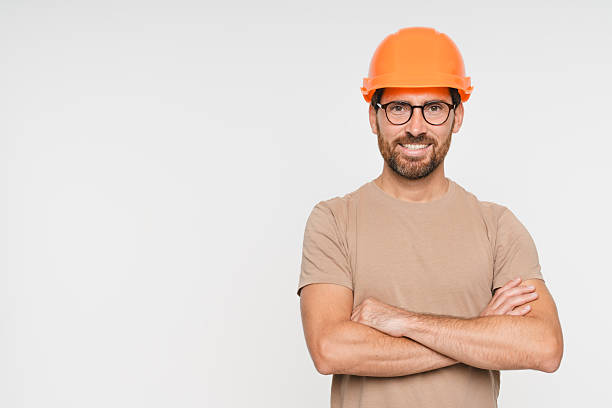 istock Construction worker man with crossed arms and smile, architect or engineer in building industry on white studio background. Professional builder male contractor with helmet, mockup copy space. 2248439413