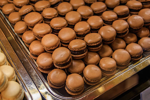 Zurich, Switzerland - November 30, 2024: Rows of small chocolate Luxemburgerli macarons with cream filling on display at Sprungli chocolatier