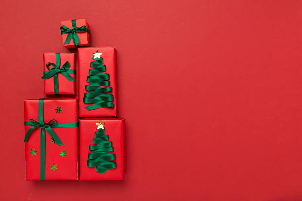 istock Gift boxes in Christmas tree shape on color background, top view 2248441100