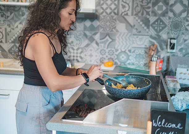 istock Home cook preparing breakfast. Woman preparing eggs for the family's breakfast. 2248443531