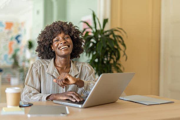 istock Smiling woman engaged in work moment with laptop 2248447298