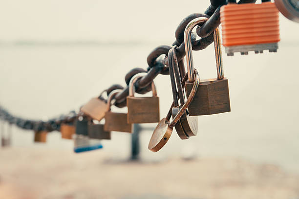 Locks of love symbolize everlasting bonds along a sturdy, aged chain. Toronto, ON