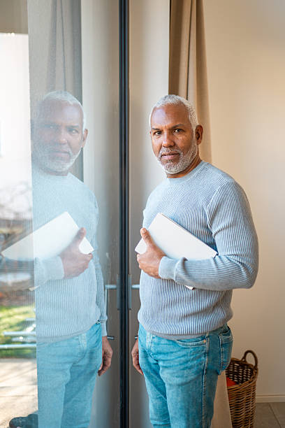 istock Mature Hispanic Male Holding Document in Bright Room 2248448332