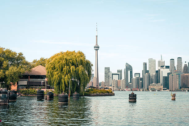 istock Toronto cityscape featuring a serene lake view, tall tower, and leafy trees. 2248448411
