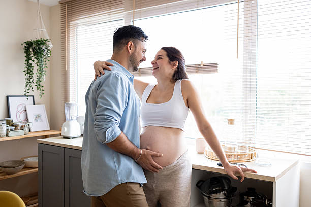 istock Pregnant couple sharing loving moment in kitchen 2248449511