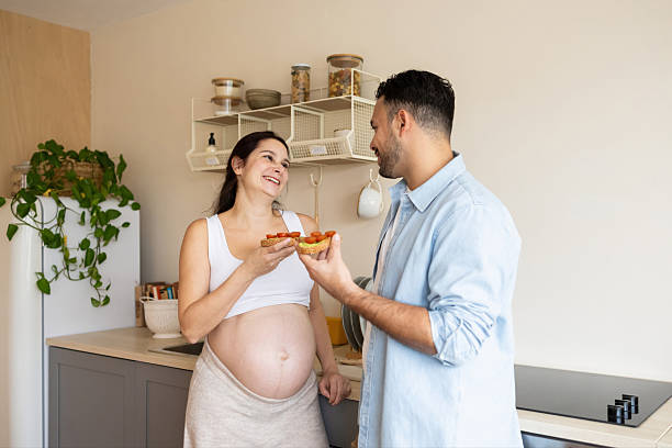istock Expecting couple sharing healthy snack in kitchen 2248449696