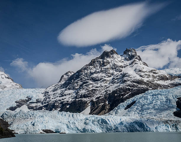 A height of the glacier is demonstrated by contrast with the boat next to it