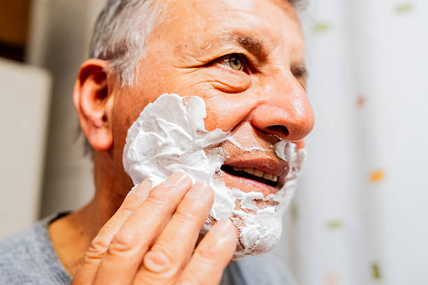 Senior man applying shaving cream at home
