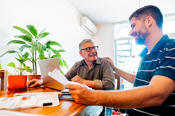 istock Father and son talking while doing home finance at home 2248450542