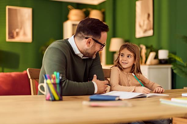 istock Family Homework Moment: Dad Helps Daughter With Schoolwork At Cozy Home Table 2248451920