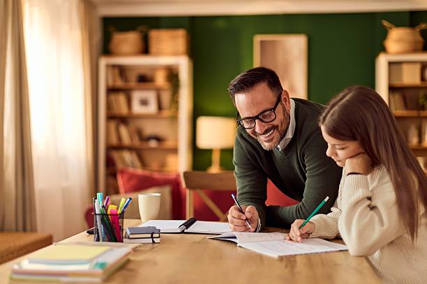A dad helps his daughter with homework at a cozy home table, fostering learning and family bonding.