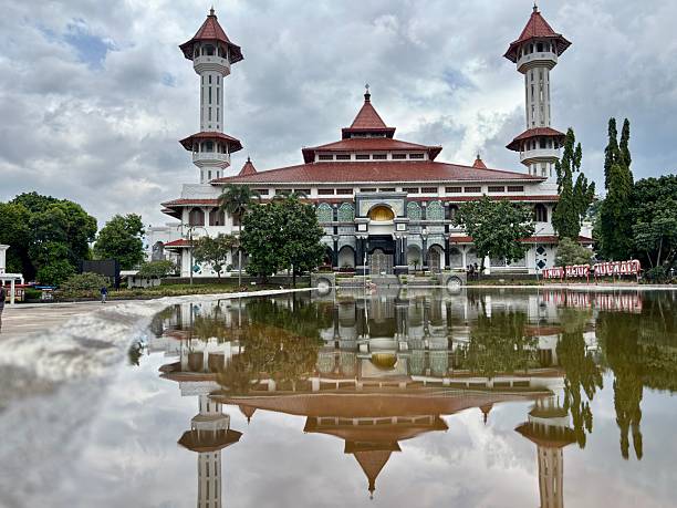 istock Grand Mosque of Cianjur, West Java, Indonesia, featuring distinctive architecture, twin minarets, and reflective courtyard pool under a cloudy sky. 2248454521