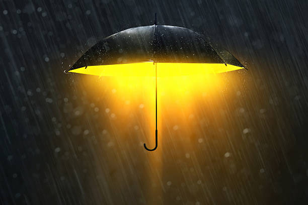 istock Glowing shiny black umbrella in the rain on dark background 2248455723