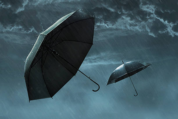 Two black umbrella flying in sky, heavy rain dark cloudy storm