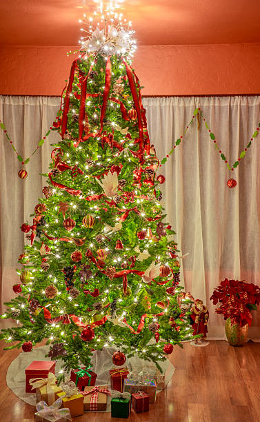 istock Christmas Tree in front of a curtained window with fruit and birds decorations 2248456448