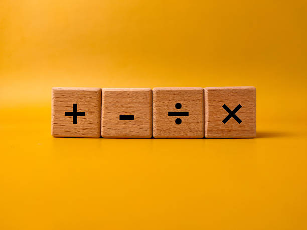 istock The image displays four wooden blocks with basic mathematical operation symbols on a yellow background 2248457489