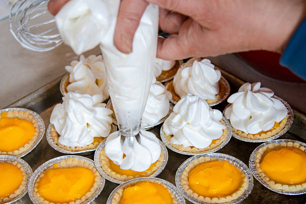 istock Piping fresh meringue onto lemon tarts in home kitchen 2248458590