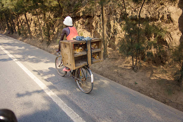 Kigali Rwanda - September 9 2025; Chickens in cage on back of bicycle being transported.