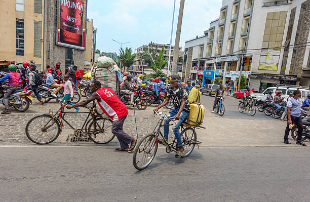 Nyange Rwanda - September 8 2025; Hectic Rwandan city street intersection with cyclists and carts loaded with goods being transported among motorbikes and pedestrians.