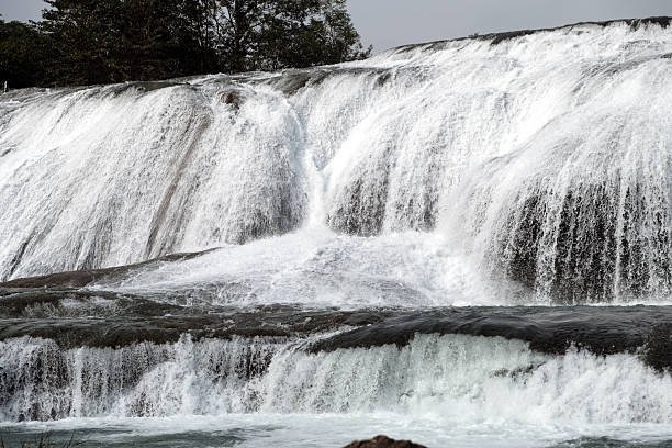 View of the Doupotang Waterfall. It is a 105-meter-wide and 21-meter-high waterfall in Huangguoshu Waterfall Scenic Area, Guizhou, China. The top of the waterfall is the widest among all of the Huangguoshu waterfalls.