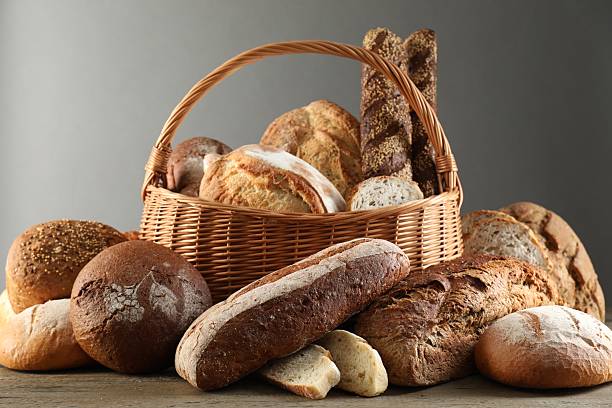istock Wicker basket with different types of fresh bread on wooden table 2248468278