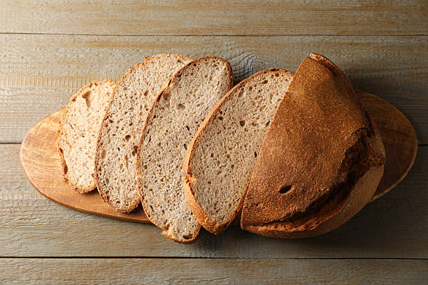 istock Freshly baked cut sourdough bread on wooden table, top view 2248468330