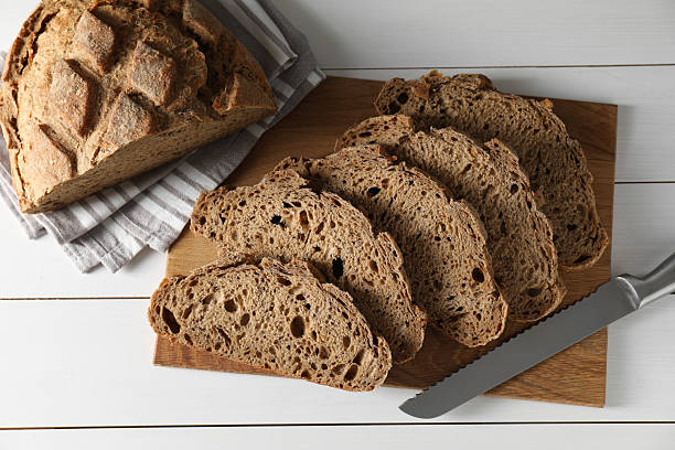 istock Freshly baked cut sourdough bread on white wooden table, top view 2248468366