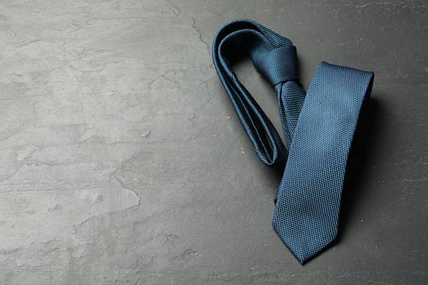 istock One blue necktie on grey textured table, top view. Space for text 2248469229